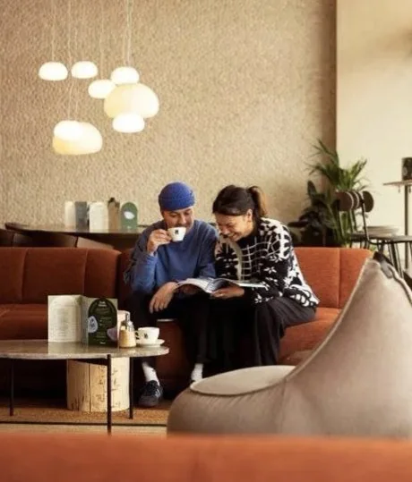 Two friends sharing coffee on a sofa